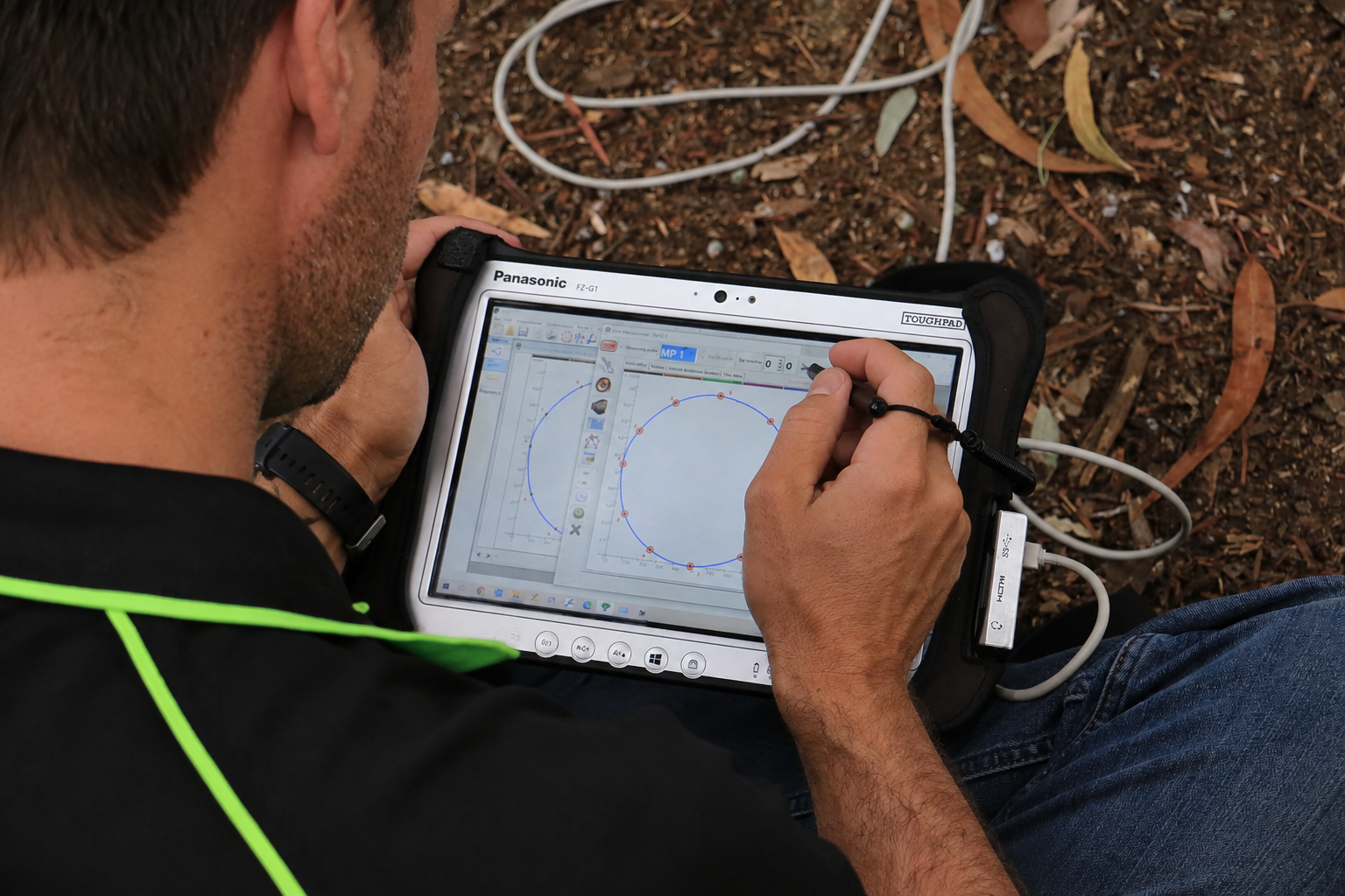 Arborisculpture arborist using a Panasonic Toughbook to record field data during a tree health and condition assessment